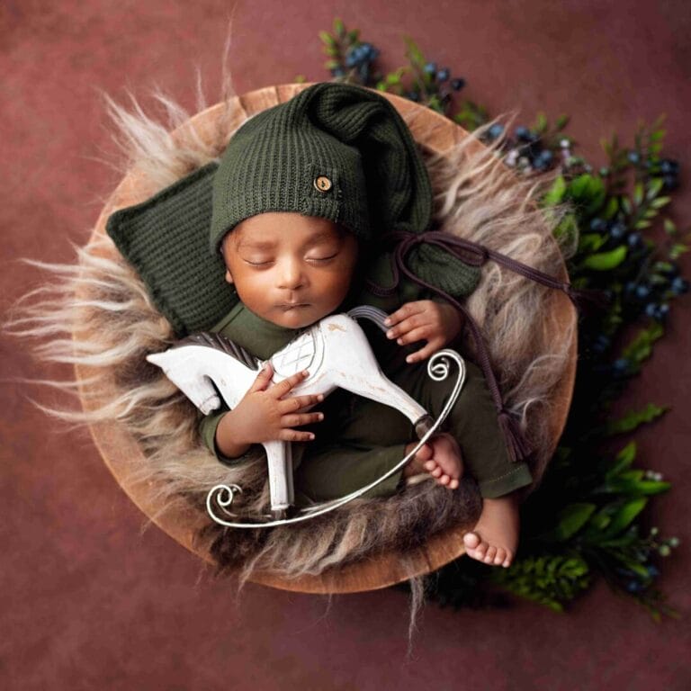 Miminko v pleteném oblečku s hračkou – newborn focení v rekvizitě