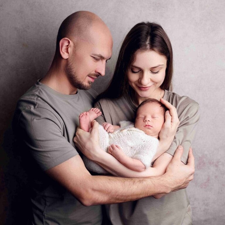 Umělecký portrét rodičů s novorozeným miminkem v náručí